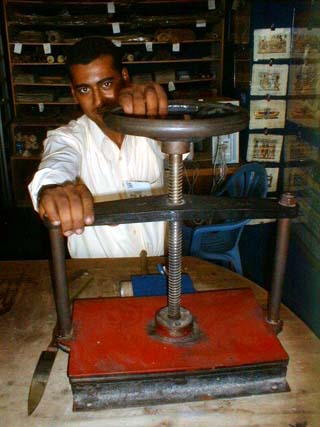 Papyrus strips being pressed with a press